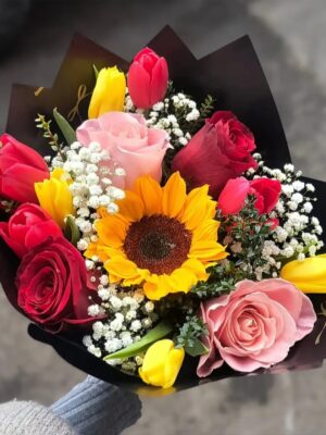 Ramo redondo con un mix de flores de estación incluye tulipanes rosas y girasol